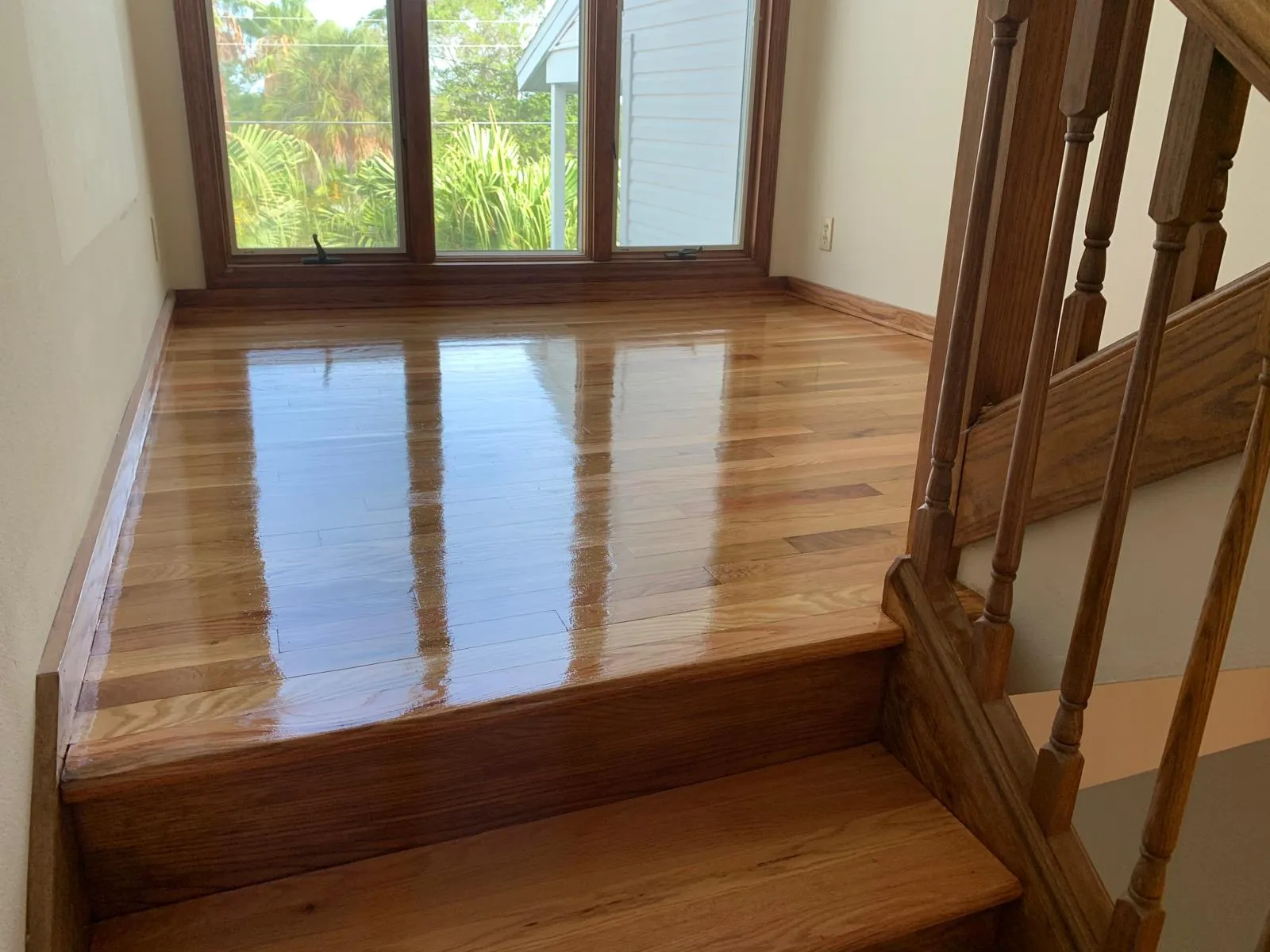 Hardwood landing with a wet coat of polyurethane drying to a mirror finish