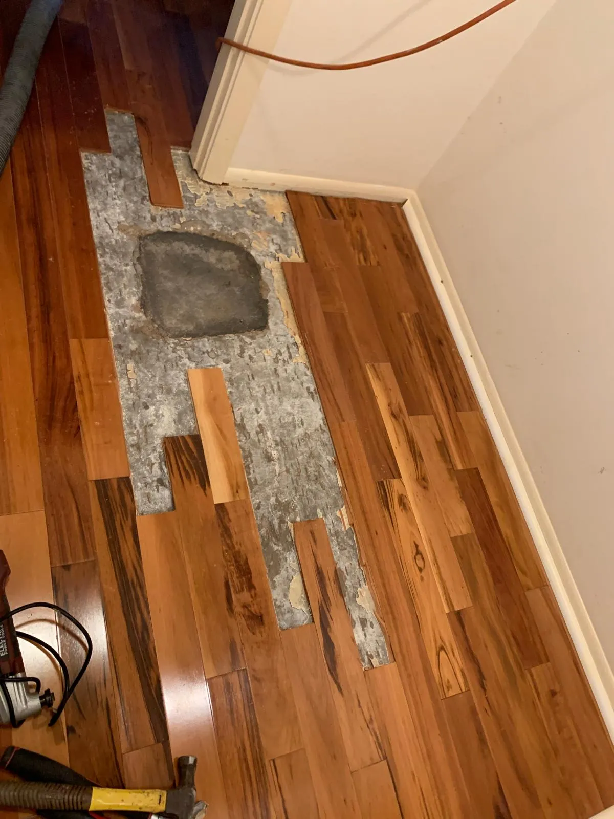 Prepared subfloor with new tigerwood boards being fitted into the surrounding floor