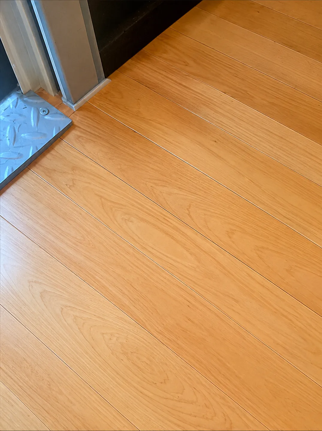 The same maple floor after sanding and refinishing — damage gone, smooth even finish