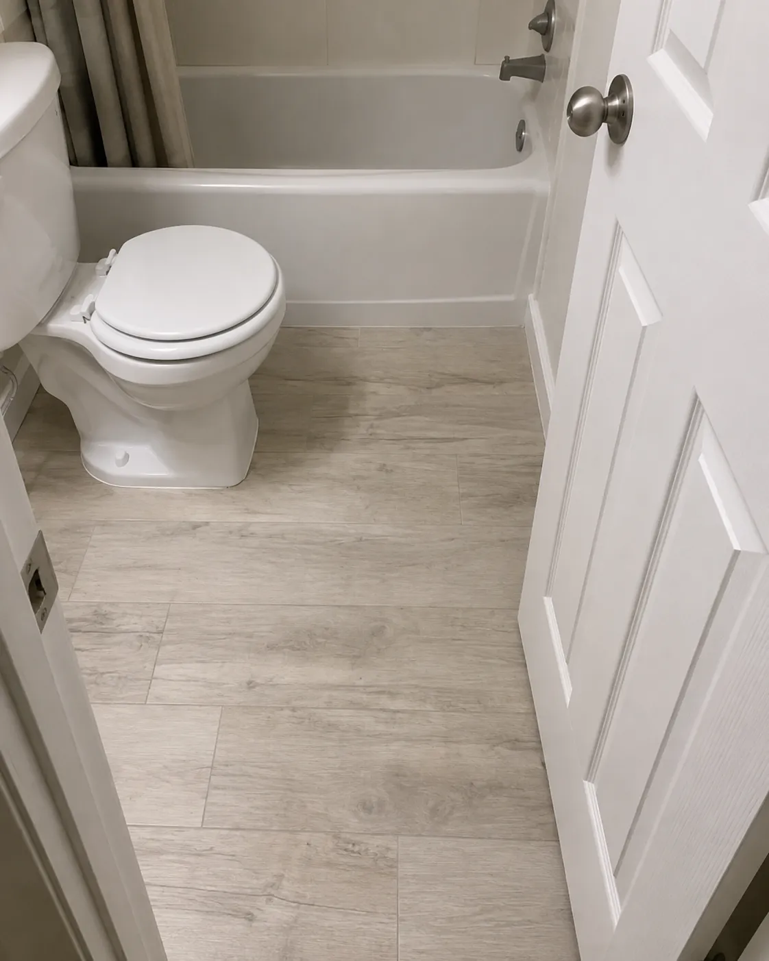 Waterproof driftwood-look plank flooring installed in a Sarasota bathroom