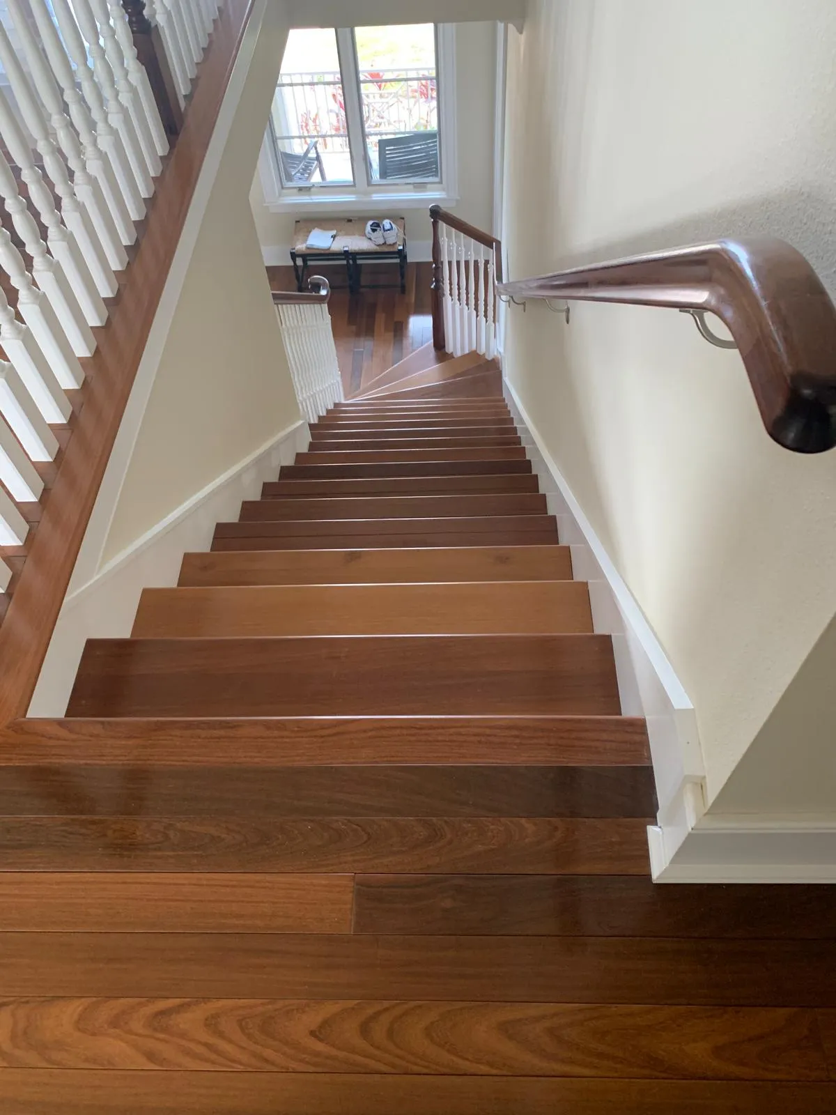 Brazilian cherry staircase with white balusters and matching hardwood landing in Sarasota