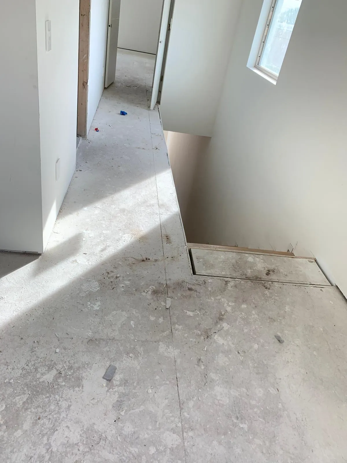 Bare plywood subfloor prepared before hardwood stair and hallway installation in Sarasota