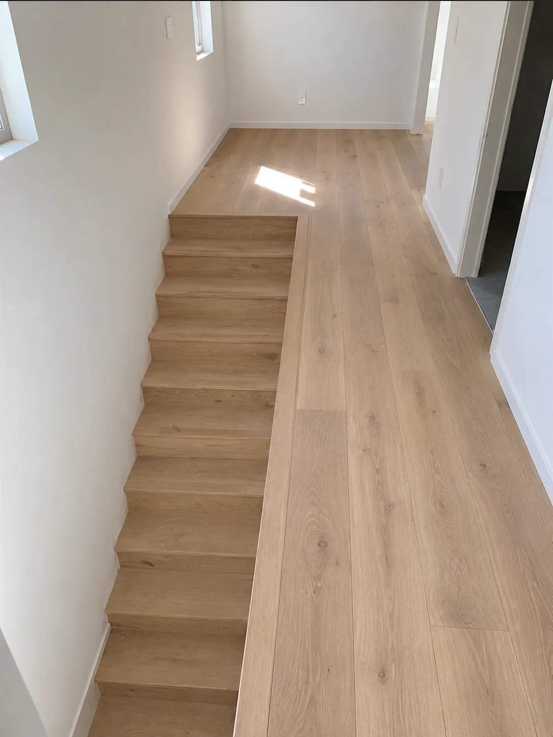 Finished white oak staircase and hallway floor installed by EGR Wood Floors in Sarasota